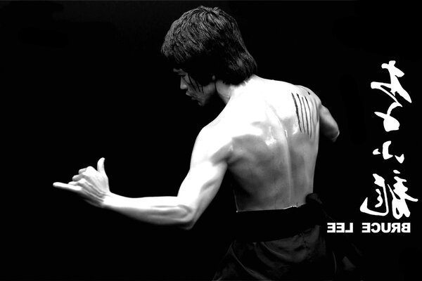 Bruce Lee with his back in a fighting stance