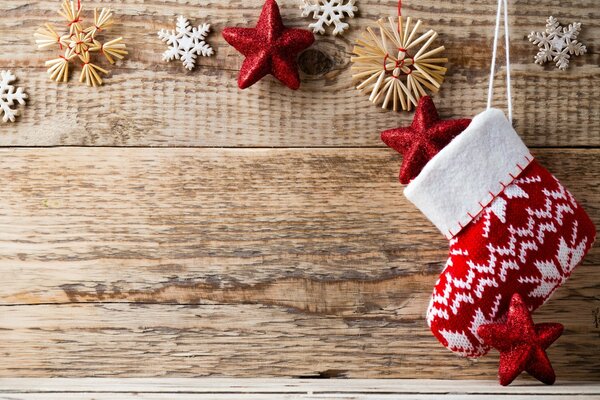 On the wooden wall there is a Christmas sock and toys