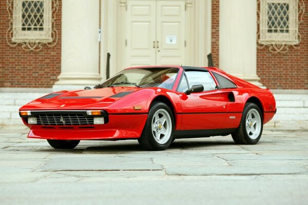 Ferrari rojo en casa con columnas