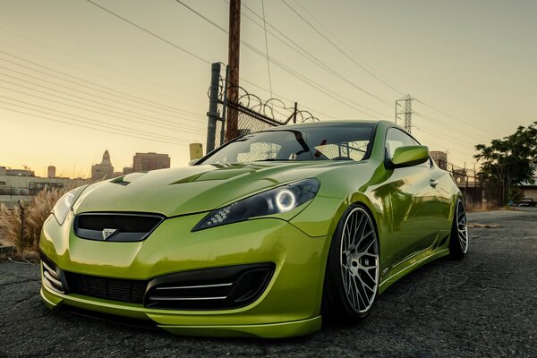 Light green sports car on the outskirts of the city near the power line