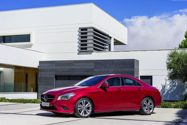 Mercedes rouge et un bâtiment de style techno