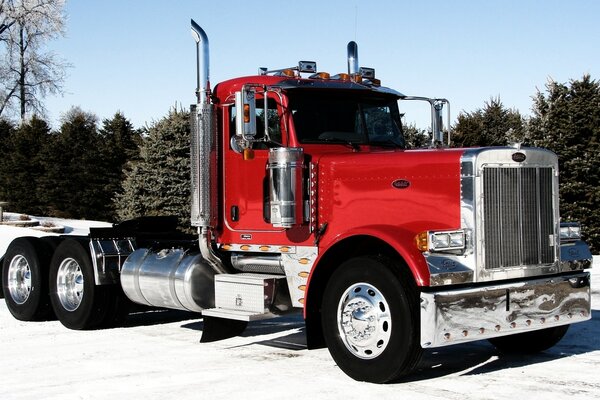 Nuevo tractor rojo en la carretera de invierno