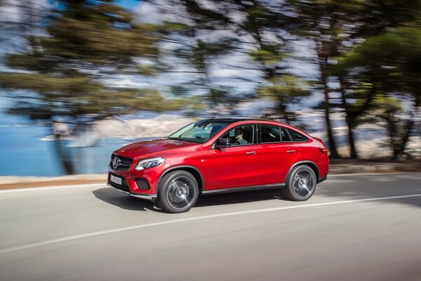 Mercedes Benz rojo monta en el camino