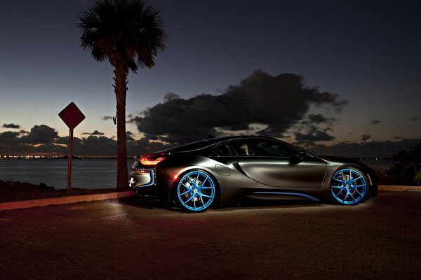 Coche en las Llantas azules contra el cielo nocturno