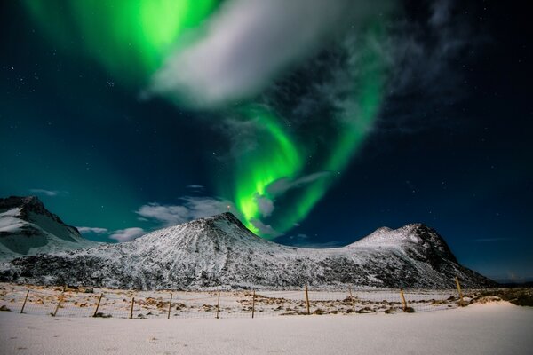 Bagliore verde nel cielo vicino alle montagne