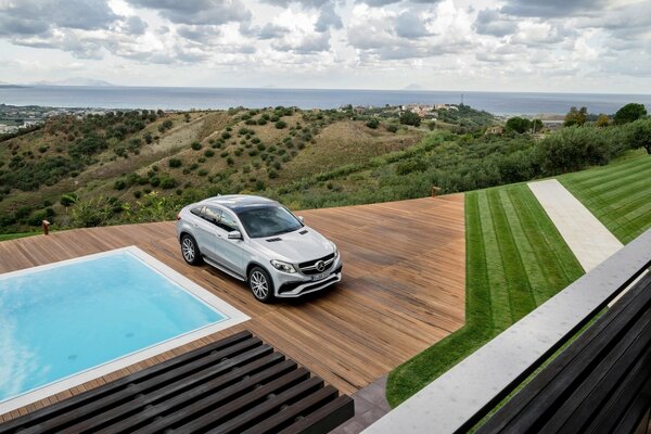 Coche junto a la piscina en medio de un paisaje de montaña