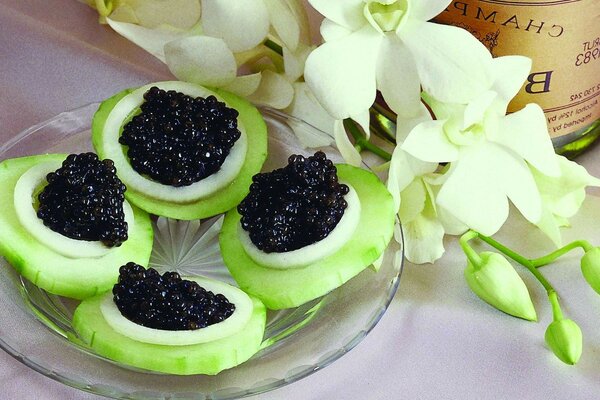 Collation avec des cercles de concombre et de caviar noir