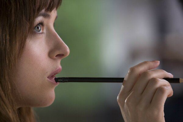 A thoughtful girl with a pencil in her hands