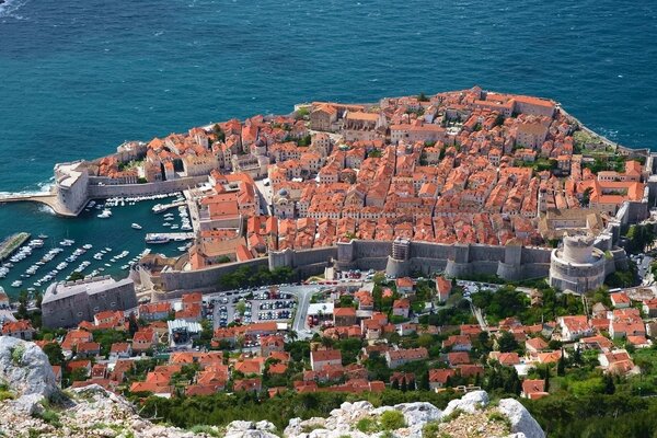 The seashore is built up with buildings with red roofs