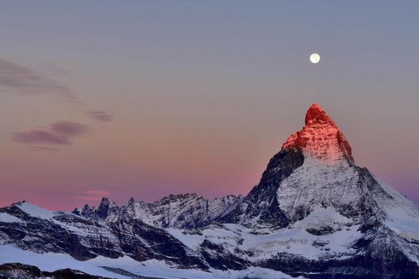 Luna sobre la cima de una montaña monumental