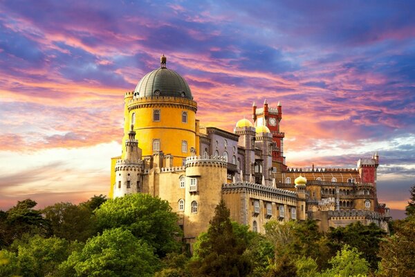 Grande belo castelo na montanha contra o fundo do céu rosa e azul ao pôr do sol