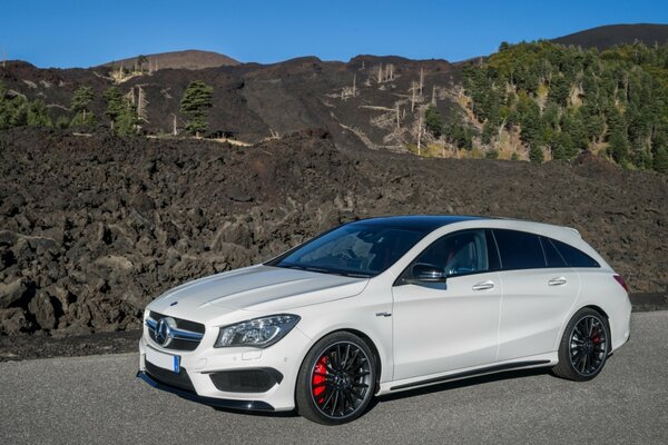 Coche y naturaleza. Mercedes-benz en el fondo de rocas y bosques