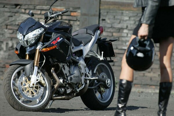 Girl stand in front of a sports motorcycle