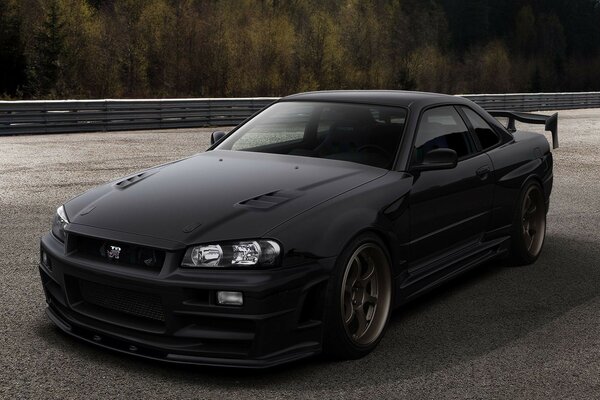 A black sports car on an asphalt road