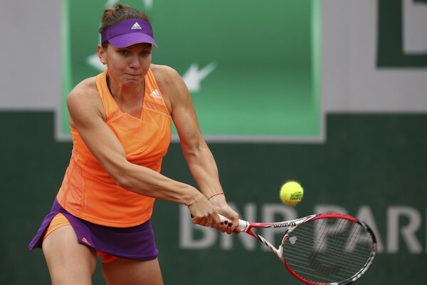 Tennisspielerin schlägt mit dem Schläger auf den Ball