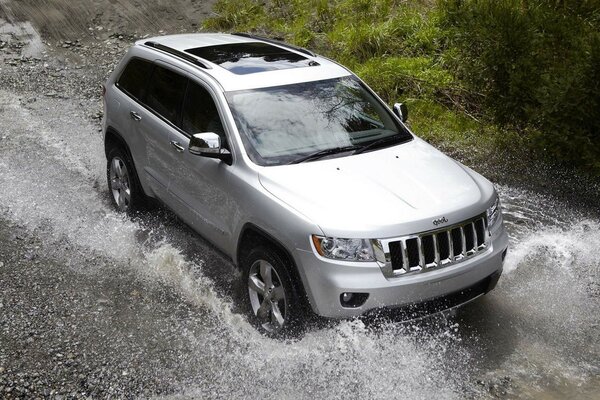 The SUV car is driving through the mud