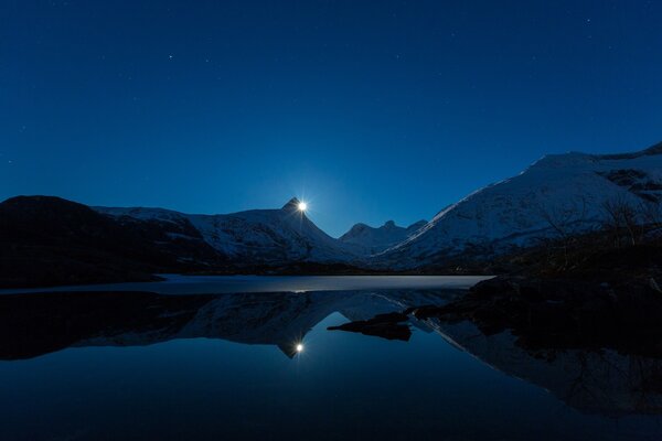 Sunrise in the snowy mountains by the lake