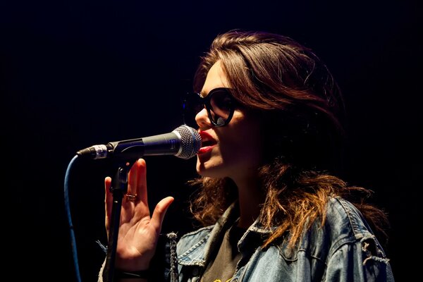 Concert photo of a musician girl with a microphone