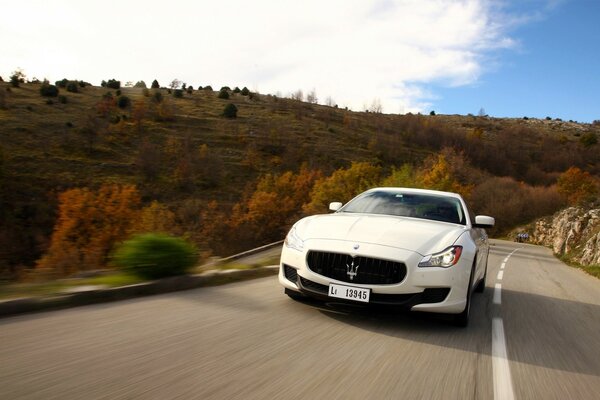 Maserati blanco en un hermoso camino