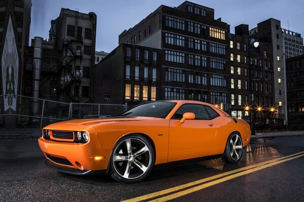 Voiture orange sur fond de ville de nuit