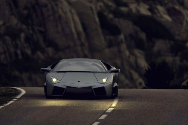 A lamborghini car hurries along the asphalt on a blurry background of mountains