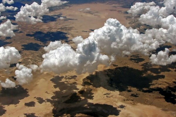 Blick aus dem Bullauge des Flugzeugs. Die Wolken