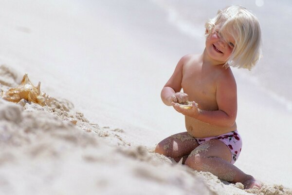 Kind spielt am Strand im Sand