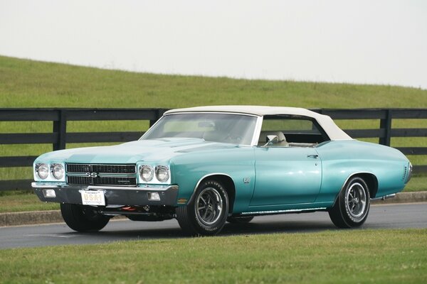 Chevrolet car on the background of green hills