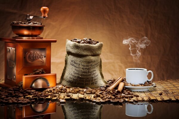 A fragrant cup of coffee next to a coffee grinder