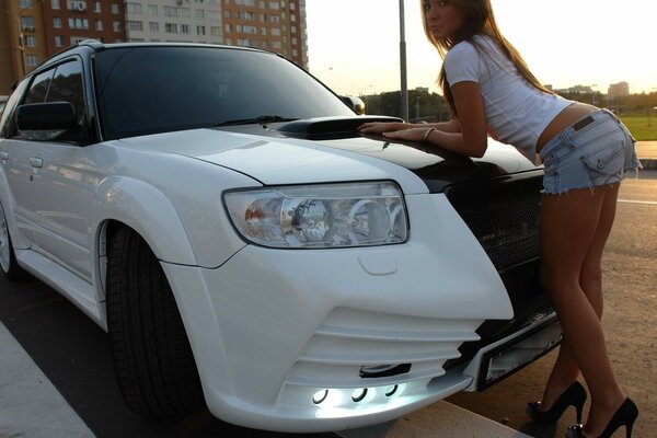 A girl poses at a white car