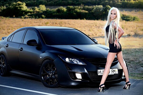 Beautiful girl at a powerful car