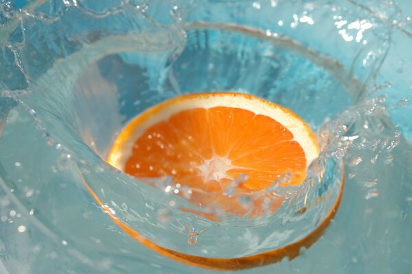 A slice of orange falls into the water