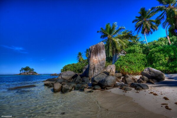 Praia tropical à beira-mar. Rochas na costa