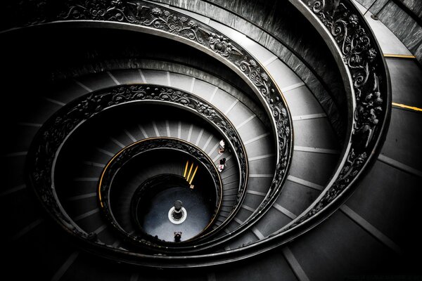 Escalier en colimaçon avec des clôtures à motifs dans les tons gris et noir