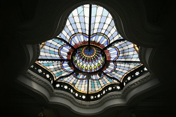 Inside, the ceiling of the building is decorated with a complex dome with an ornament of colored glass