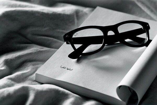 Black glasses on an open book