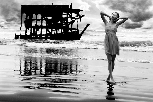 Девушка позирует в платье на пляже у океана