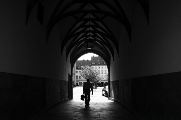 A silhouette of a man against the background of a gray arch