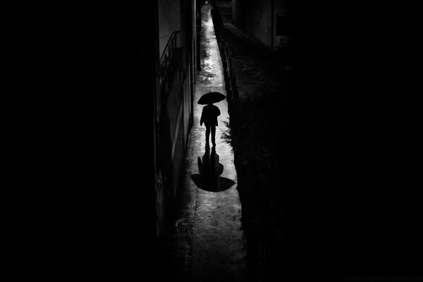 Силуэт человека под зонтом в черно- белом цвете