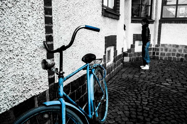 La bicicleta azul se encuentra sobre un fondo blanco y negro