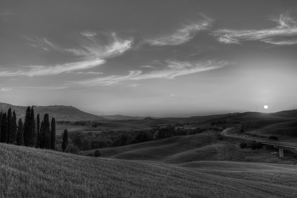 El sol blanco y negro se pone detrás del horizonte