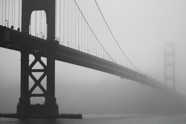 Schwarz-Weiß-Foto einer Hängebrücke im Nebel