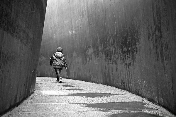 Baby schreitet alleine wie ein Erwachsener die Straße hinunter