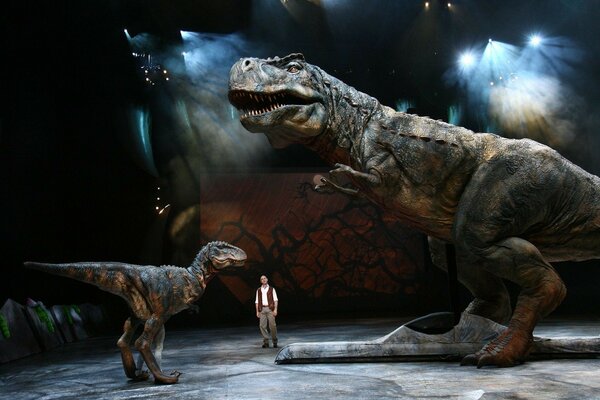 A man next to dinosaur statues