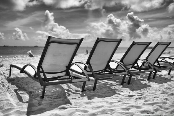 Black and white ioto of a chair on the sea