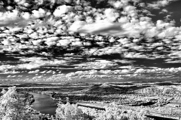 Black and white photo of the landscape in winter river and hills from a height