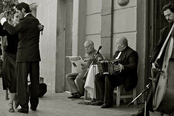 Músicos de rua tocam para um casal dançando