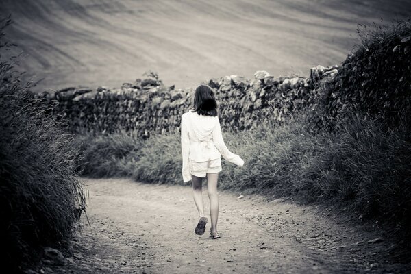 Chica caminando en un camino rural