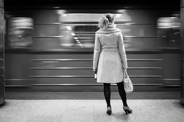 Mulher fica no metrô com fundo preto e branco