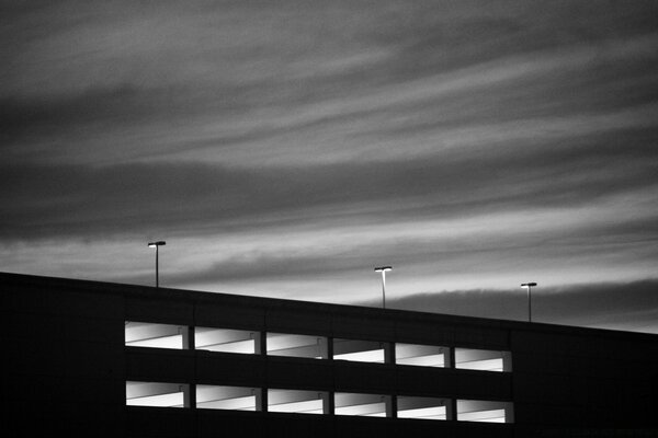 Foto en blanco y negro del puente de la puesta del sol con linternas